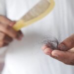 Mulher cuidando dos cabelos, relacionado a queda de cabelo feminina